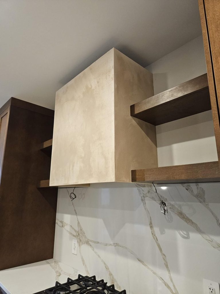 Architectural range hood surround with a limestone-style finish
